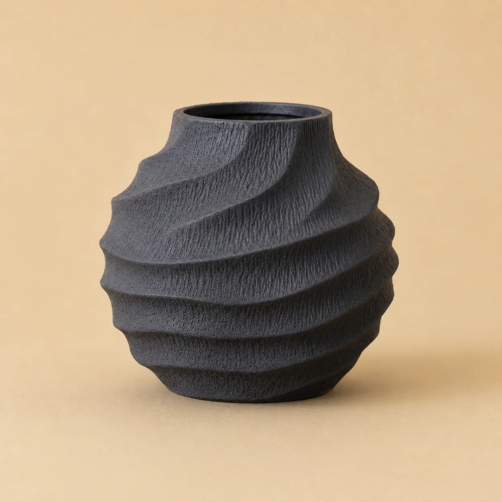 Seitenansicht der schwarzen Keramikvase mit plastischer Wellenstruktur